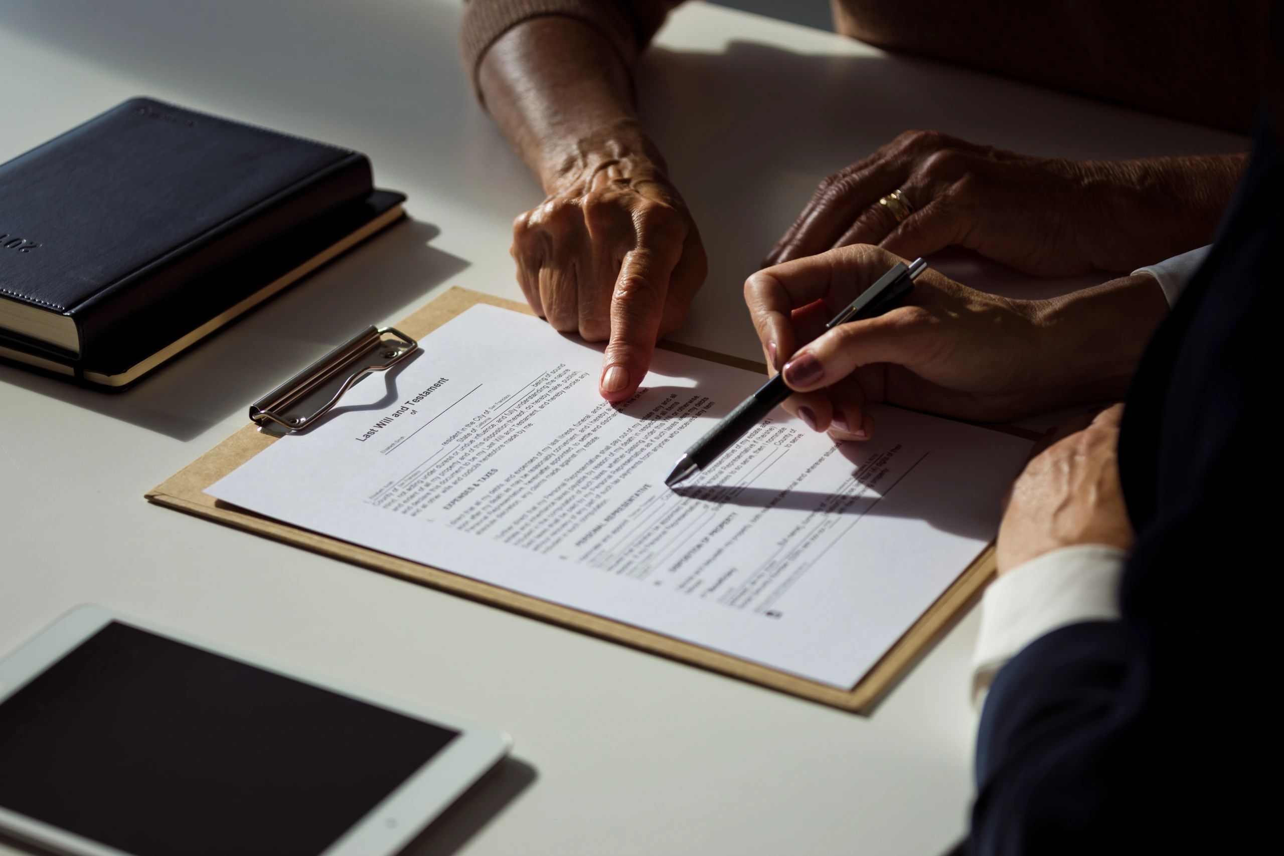 Close-up of hands reviewing estate or legal documents with a professional